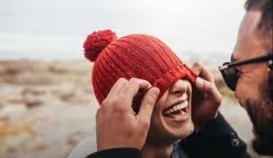 Kvinde med rygsæk smiler, mens hun går med en ven på landet