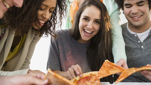 gruppe venner, der spiser pizza